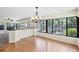 Bright sun room with hardwood floors, large windows, and an elegant chandelier at 8036 Conservatory Cir, Sarasota, FL 34243