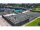 Active community features tennis courts with shaded seating area and residents enjoying a game at 8036 Conservatory Cir, Sarasota, FL 34243