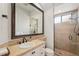 Bathroom with walk-in shower, cream tile, large mirror and vanity at 805 3Rd E St, Palmetto, FL 34221
