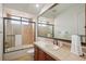 Bright bathroom featuring earth tone tiles in shower and flooring plus a large mirror above the vanity at 805 3Rd E St, Palmetto, FL 34221