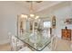 Elegant dining room featuring a glass top table, tile floors, and an arched doorway to the living room at 805 3Rd E St, Palmetto, FL 34221