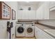 Well-equipped laundry room with washer, dryer, ample storage, and adjacent sink at 805 3Rd E St, Palmetto, FL 34221