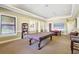 Well-lit game room equipped with a billiard table, bookshelves, and comfortable seating for recreation at 8341 38Th Street E Cir # 303, Sarasota, FL 34243