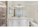Well-lit bathroom with white cabinets, a stone countertop, and a tiled shower at 920 Tidewater Shores Loop # 304, Bradenton, FL 34208