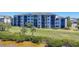 Exterior view of a three-story condominium complex with lush landscaping and waterfront at 920 Tidewater Shores Loop # 304, Bradenton, FL 34208