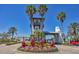 Well-maintained community entrance with palm trees, tower and manicured landscaping at 920 Tidewater Shores Loop # 304, Bradenton, FL 34208