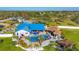 Stunning aerial view showcasing a custom home with a blue roof, luxurious pool area, tiki bar, and beautiful landscaping at 9902 284Th St E E St, Myakka City, FL 34251
