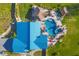 Aerial shot of an estate highlighting the pool, tiki huts, landscaping, and unique roof design at 9902 284Th St E E St, Myakka City, FL 34251