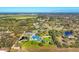 Expansive property featuring a house, pool, tiki huts, and lush landscaping, as seen from above at 9902 284Th St E E St, Myakka City, FL 34251
