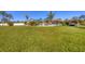 Lush backyard with meticulously maintained lawn, tropical landscaping, and tiki hut seating area at 9902 284Th St E E St, Myakka City, FL 34251
