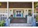 Inviting front porch with a beautiful blue front door, seating area, and stylish decor for relaxed outdoor living at 9902 284Th St E E St, Myakka City, FL 34251
