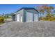 Large garage featuring three bays, paved driveway, and ample parking space for multiple vehicles or storage at 9902 284Th St E E St, Myakka City, FL 34251