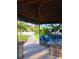 Seating area with cushioned furniture inside a tiki hut with lighting near a pool on a sunny day at 9902 284Th St E E St, Myakka City, FL 34251