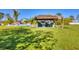 Inviting tiki hut with comfortable seating offers shade and relaxation amidst lush landscaping on a sunny day at 9902 284Th St E E St, Myakka City, FL 34251