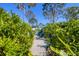 Landscaped backyard walkway with Adirondack chairs offers relaxation and privacy at 9902 284Th St E E St, Myakka City, FL 34251