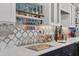 Custom wet bar with marble countertops, mosaic tile backsplash, and stylish glass storage at 9902 284Th St E E St, Myakka City, FL 34251