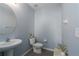 Well-lit half bath with a pedestal sink, round mirror, and tasteful decor at 108 San Avellino Ct, Bradenton, FL 34208