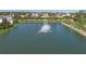 Aerial view of a serene pond with a fountain, surrounded by lush greenery and homes at 108 San Avellino Ct, Bradenton, FL 34208
