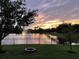 A view of a pond with a fountain at sunset as seen from backyard with a firepit at 108 San Avellino Ct, Bradenton, FL 34208