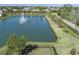 Aerial view of a serene pond with a fountain, surrounded by lush greenery and homes at 108 San Avellino Ct, Bradenton, FL 34208