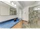 Modern bathroom with a blue countertop vanity and glass-enclosed tiled shower at 1112 67Th Nw St, Bradenton, FL 34209