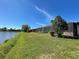 Backyard with a green lawn and screened patio overlooking a serene lake at 11331 Bertolini Dr, Venice, FL 34292