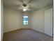Bright bedroom features neutral carpet, ceiling fan, and a window offering natural light at 11331 Bertolini Dr, Venice, FL 34292