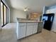 Island kitchen with stainless dishwasher, breakfast bar, white cabinetry and tile floors at 11331 Bertolini Dr, Venice, FL 34292