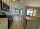 Bright kitchen features cream cabinets, stainless appliances, breakfast nook, and views of the lake at 11331 Bertolini Dr, Venice, FL 34292