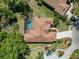 Aerial view of the house highlighting the screened pool, landscaping, and roof at 11419 Pine Lilly Pl, Lakewood Ranch, FL 34202