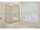 Bathroom featuring a glass shower, a soaking tub, and a window with blinds at 11419 Pine Lilly Pl, Lakewood Ranch, FL 34202