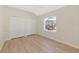 Bedroom featuring wood floor, a double closet and a window view at 11419 Pine Lilly Pl, Lakewood Ranch, FL 34202