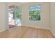 Bright bedroom featuring wood floors, sliding glass door to pool, and a large window overlooking greenery at 11419 Pine Lilly Pl, Lakewood Ranch, FL 34202