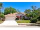 Charming single-story home with a well-manicured lawn, mature trees, and a two-car garage at 11419 Pine Lilly Pl, Lakewood Ranch, FL 34202
