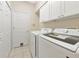 Bright laundry room with white cabinets, washer, and dryer at 11419 Pine Lilly Pl, Lakewood Ranch, FL 34202