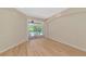 Bright room with wood floors and a slider door offering peaceful outdoor views at 11419 Pine Lilly Pl, Lakewood Ranch, FL 34202