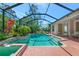 Relaxing screened-in pool area featuring tropical landscaping, a spa, and outdoor seating at 11419 Pine Lilly Pl, Lakewood Ranch, FL 34202