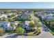 Overhead view showcases community layout with tree-lined streets, green spaces, and a serene lake nearby at 11717 Blue Hill Trl, Lakewood Ranch, FL 34211