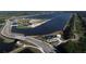 Aerial view of modern aquatic center, bridges, and a lake with a long straight path across the water at 11717 Blue Hill Trl, Lakewood Ranch, FL 34211