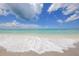 Scenic beach view showcasing clear turquoise ocean waters and a sandy shoreline with gentle waves at 11717 Blue Hill Trl, Lakewood Ranch, FL 34211