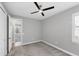 Bedroom with gray carpet, light gray walls, ceiling fan, white door and a white window at 11717 Blue Hill Trl, Lakewood Ranch, FL 34211