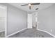 Standard bedroom with gray carpet, light gray walls, ceiling fan and a white door at 11717 Blue Hill Trl, Lakewood Ranch, FL 34211