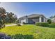 Well-maintained home exterior featuring lush green lawn, screened patio, and attached garage at 11717 Blue Hill Trl, Lakewood Ranch, FL 34211