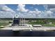Exterior shot of a modern waterfront building with blue accents, dock and beach access, and ample parking at 11717 Blue Hill Trl, Lakewood Ranch, FL 34211
