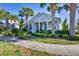 Home exterior showcases tropical landscaping, a quaint porch, and neighborhood sidewalks at 11717 Blue Hill Trl, Lakewood Ranch, FL 34211
