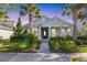 Charming single-story home featuring lush landscaping, a brick pathway, and a welcoming covered porch at 11717 Blue Hill Trl, Lakewood Ranch, FL 34211