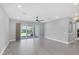 Bright living room features gray plank flooring, neutral walls, and a sliding glass door to backyard at 11717 Blue Hill Trl, Lakewood Ranch, FL 34211