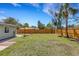 Wide backyard features a lush lawn, wooden fence, fire pit, and mature trees, perfect for outdoor activities at 1200 74Th N St, St Petersburg, FL 33710
