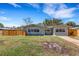 Charming single-story home featuring a well-maintained lawn and a wooden privacy fence at 1200 74Th N St, St Petersburg, FL 33710