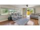 Bright living room featuring hardwood floors, ceiling fan, comfortable seating, and large windows at 1200 74Th N St, St Petersburg, FL 33710